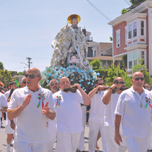 The Statue of St. Peter, draped in dollar bills and adorned with flowers, leads the procession through the city during Gloucester’s St. Peter’s fiesta.  (Susan Pollack photo)