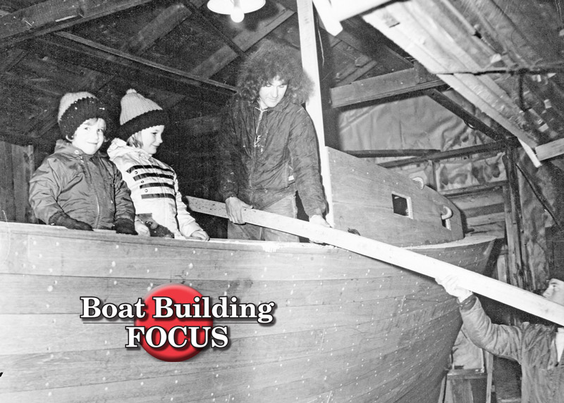 Brian, Bruce Jr., and Bruce Sr. receiving a plank from Leonard Eugley.  (Red Boutilier photo, courtesy Farrin’s Boatshop)